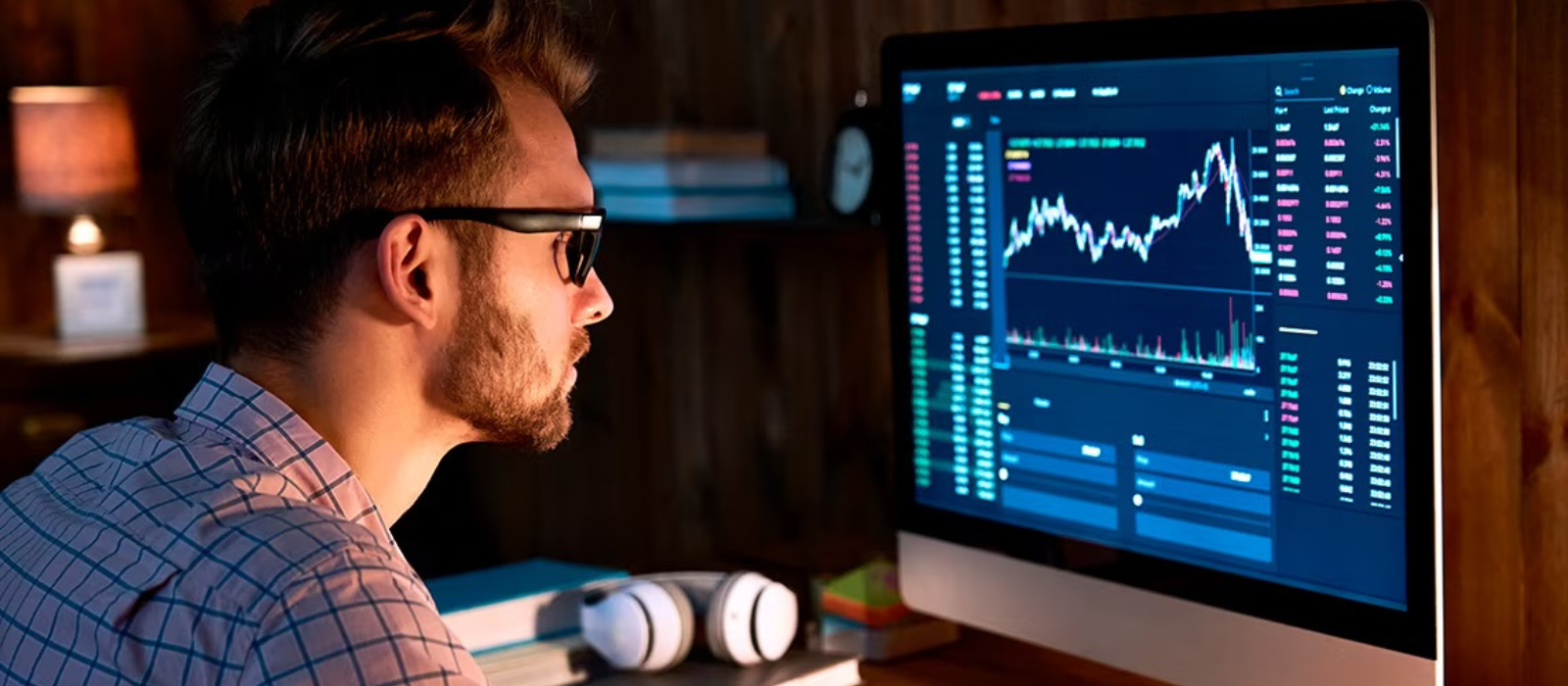 Hombre analizando gráficos de trading en un monitor