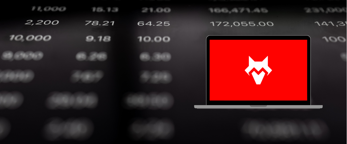 Laptop con el logo de FoxTrade Capital sobre datos de mercado en segundo plano